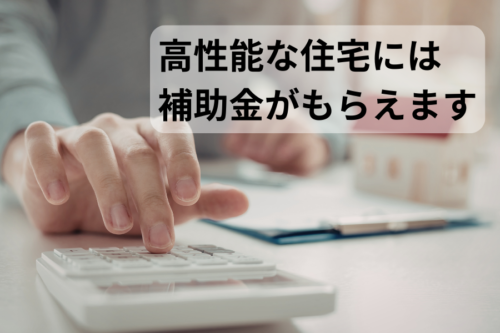 電卓を操作する手元と家の模型の写真。「高性能な住宅には補助金がもらえます」というテキストが重ねられている。